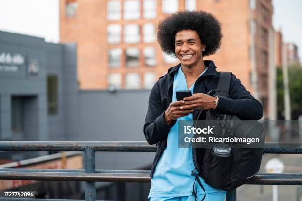 Nurse Is Using His Phone On The Streets Of The City Stock Photo - Download Image Now