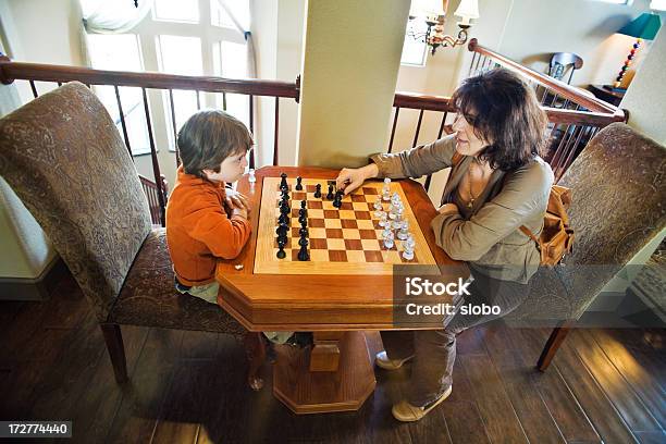 Foto de Mãe E Filho Jogando Xadrez Juntos Em Um Tabuleiro De Xadrez Integral e mais fotos de stock de Brincar