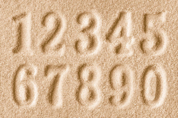 istock Imprints of numbers on a golden sand background 1727744517
