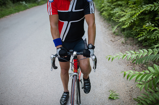 Young man, professional cyclist, enjoying in riding bicycle through the nature. Sport and recreation time.
