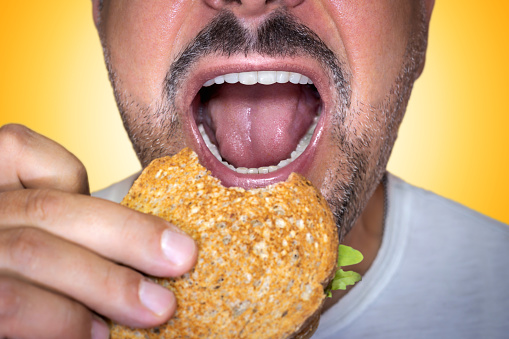 Close-up of man eating cheese toast.
