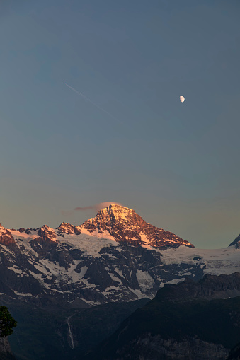 the summit of the jungfrau and the moon at sunset above wengen switzerland