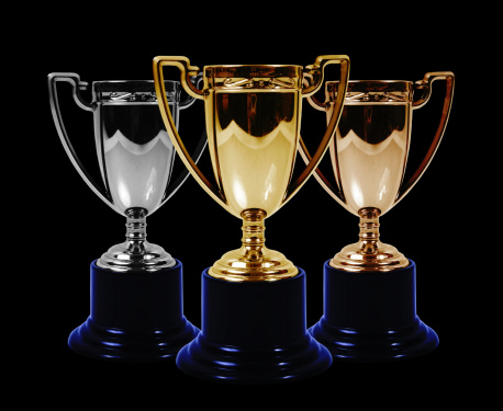 Gold silver and bronze trophies on a black background.