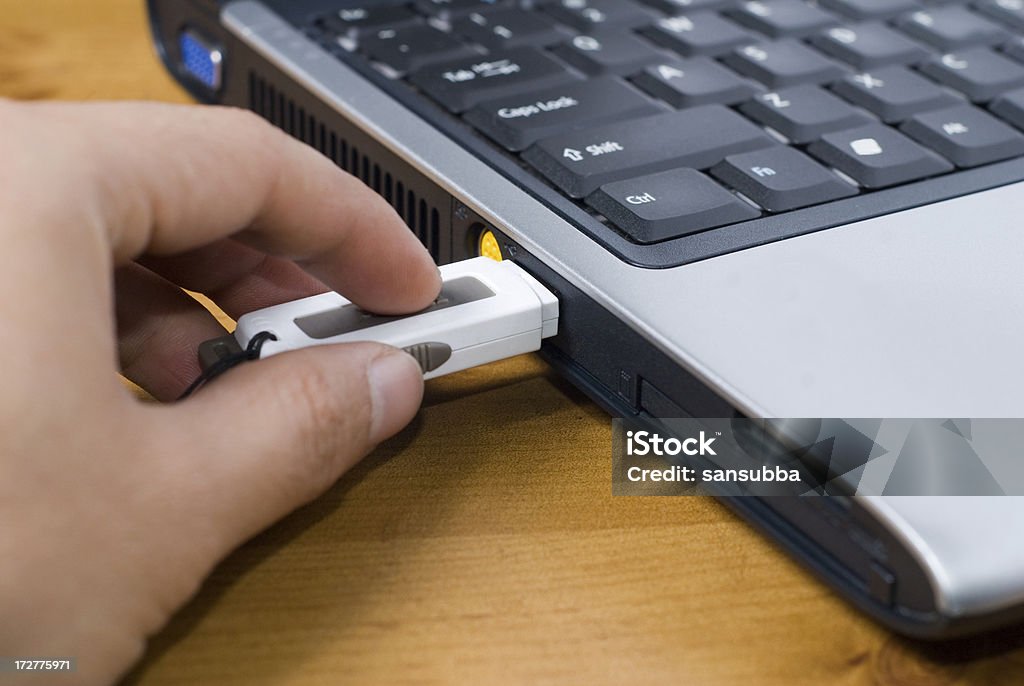 inserting pen drive hand inserting pen drive on a laptop USB Stick Stock Photo