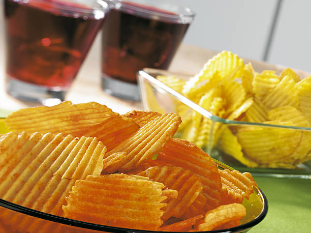Potato chips and drinks on a table stock photo