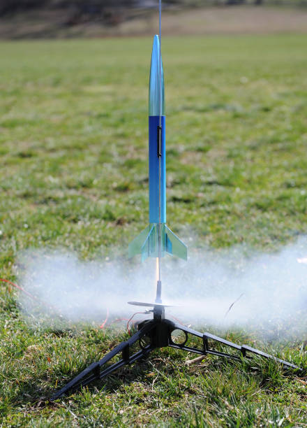 Model Rocket Launching "A blue model rocket emits smoke and flame, split-seconds after lifting off from it's launch pad." model rocket stock pictures, royalty-free photos & images