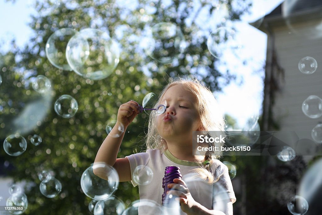 Dziewczynka wieje pęcherzyki powietrza - Zbiór zdjęć royalty-free (Dziecko)
