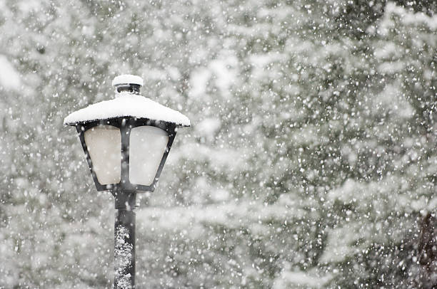 An image of a street lamp in a snow blizzard in April stock photo