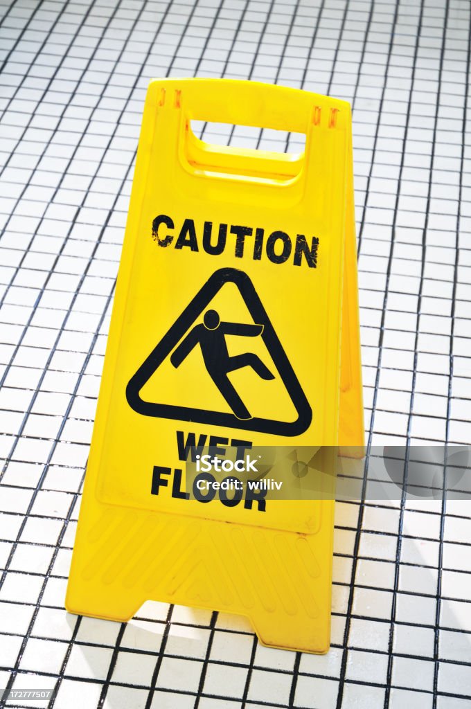 Caution Sign A caution wet floor signboard in a men's toilet. Caution Wet Floor Stock Photo