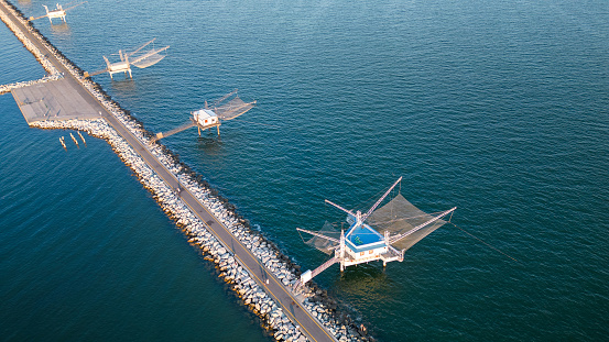 Traditional fishing industry, fisher house and nets on the coast of Marina di Ravenna, Italy - mediterranean sea. Aerial view