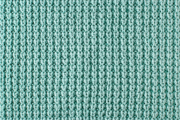 istock Texture of a rough knitted sweater close-up. Turquoise knitted backdrop for layout design 1727796691