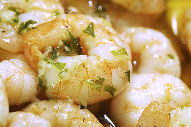 Grilled hot shrimp on a fork on a black background