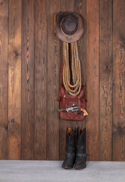 istock cowboy hat, boots and gun on a wooden floor 1727798531