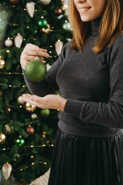 istock Smiley Woman decorating big Christmas tree 1727800712