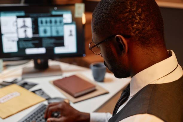 istock Close up of Black man as police detective using computer at workplace in office 1727804863