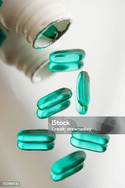 Prescription Drugs Advils On Reflective Surface Stock Photo - Download Image Now - Beauty, Bottle, Capsule - Medicine