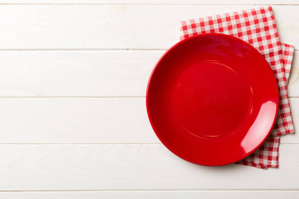 istock Top view on colored background empty round red plate on tablecloth for food. Empty dish on napkin with space for your design 1727809731