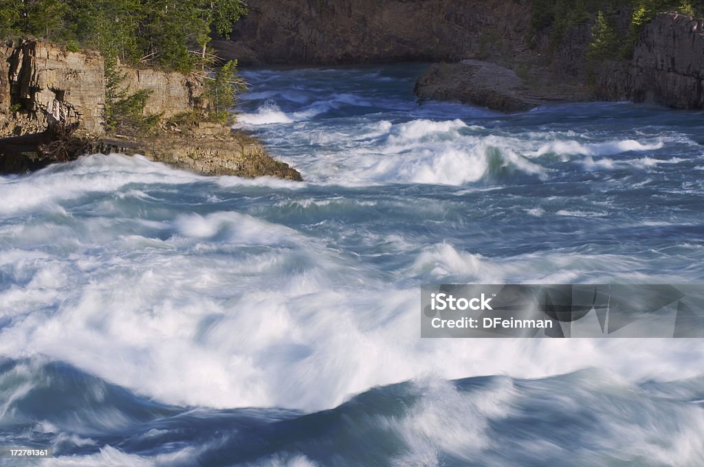 Raging River Big waves form on the Kootenai river swollen with mountain snow runoff.  Montana.  Slow shutter speed. Furious Stock Photo