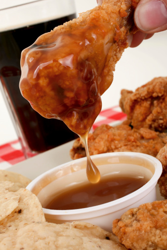 Tasty wing sauce drips from a crispy chicken wing.