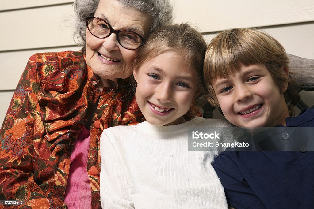 Bisnonna seduto sulla veranda con nipoti - Foto stock royalty-free di 80-89 anni