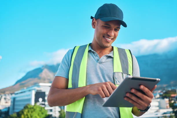 istock City, tablet and typing contractor, happy man and reading online floor plan, construction site review or digital blueprint. Project manager, expert or safety inspector planning property development 1727829312