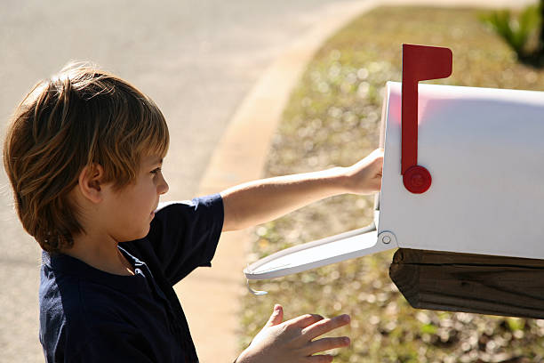 carino giovane ragazzo scenderà mail in cassetta postale - mailbox mail letter old fashioned foto e immagini stock