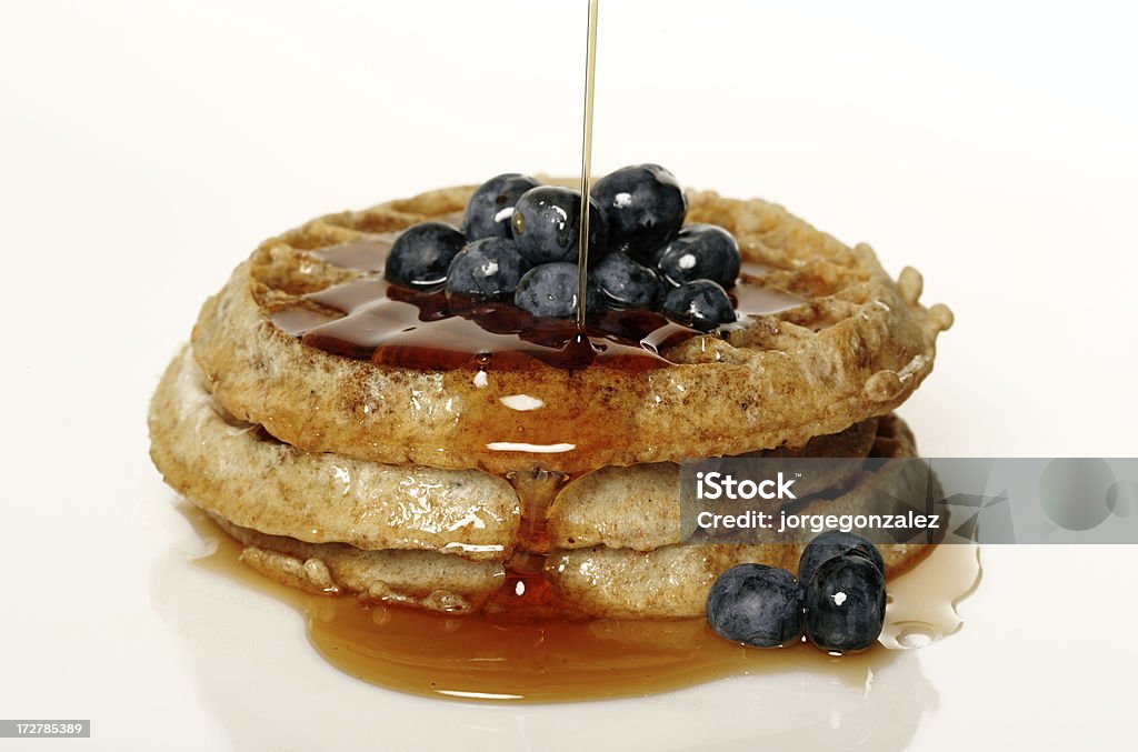 Pouring syrup on blueberry waffles Syrup Stock Photo