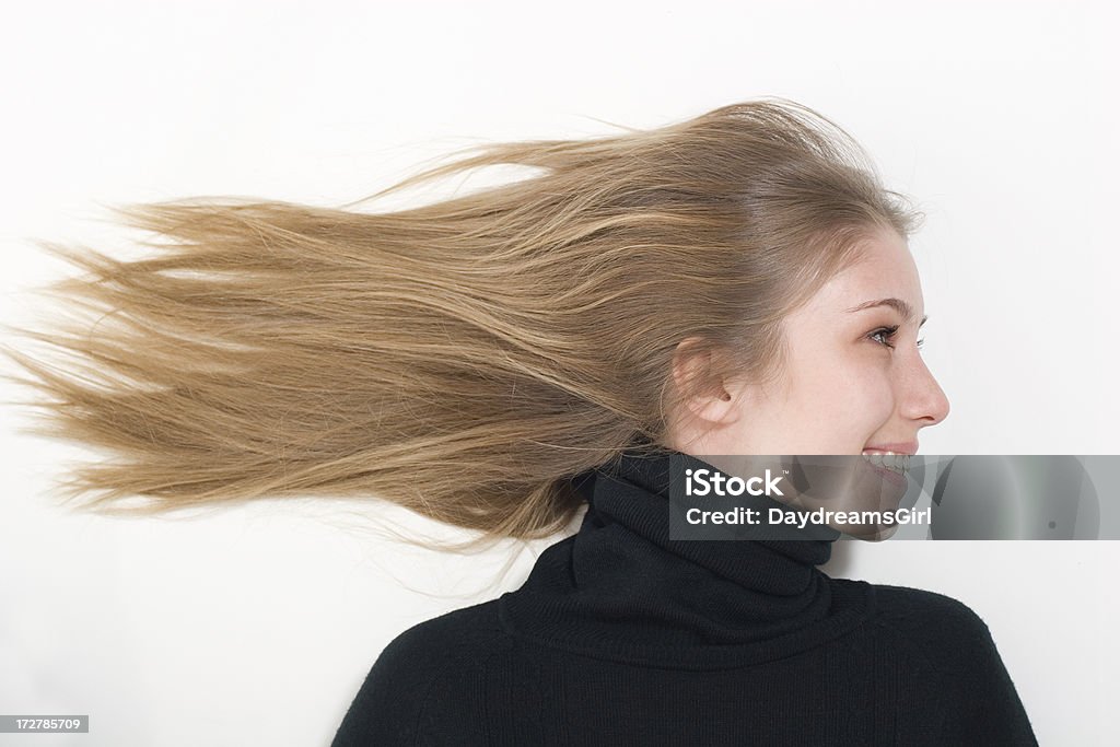 Hair Blowing in the Wind Smiling young woman with her hair blown straight out behind her. 16-17 Years Stock Photo