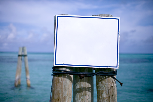 White sign mounted on the side of a dock.