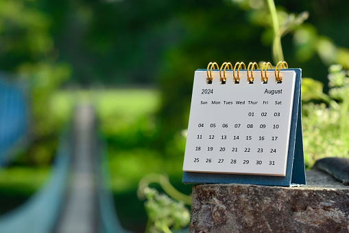 August calendar with green blurred background of hanging bridge. New year concept.