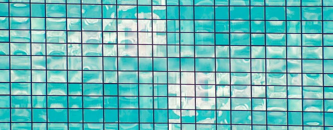 Abstract mosaic of squares in blue and white tones. The blue sky with white clouds is reflected in the mirror. The intersection of stripes creating a grid. Background image for the template.