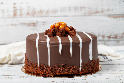 Chocolate celebration cake. Birthday cake with cream and chocolate on wooden background. patisserie products