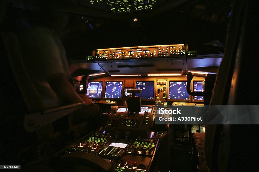 An airplane cockpit at night time Flight deck illuminated at night. Autopilot Stock Photo