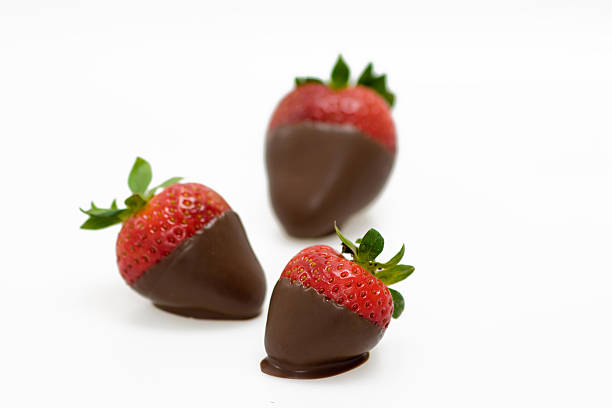 Chocolate Covered Strawberries Fresh strawberries dipped in milk chocolate fondue. White backround. chocolate covered strawberries stock pictures, royalty-free photos & images