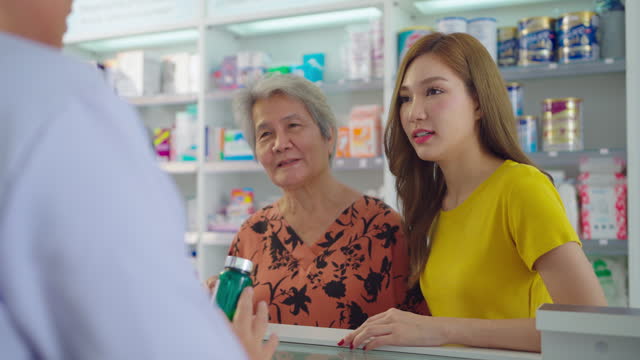 Female pharmacist talking with customer at counter in the pharmacy.
