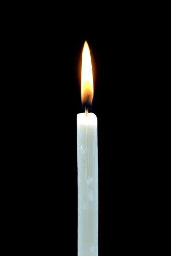 Single white candle on a black background