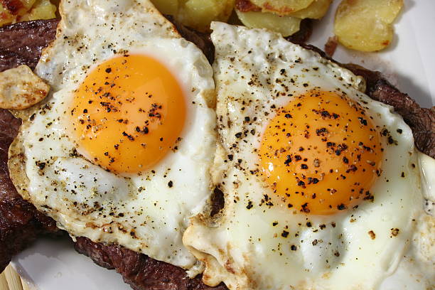 Steak with Eggs closeup of roast potatoes, steak and fried eggs steak and eggs breakfast stock pictures, royalty-free photos & images