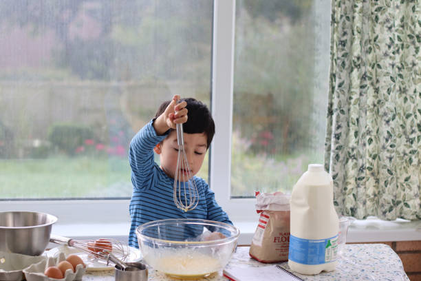 istock Child holding whisk mixing cake batter for pancake day. 1727871090