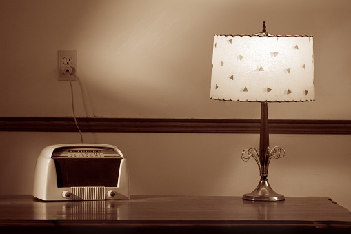 Old radio and lamp in sepia .