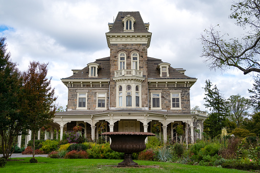 Baltimore, Maryland - October 8, 2023:  Front view of the Cylburn Mansion in Baltimore City built in 1888 by the Tyson family of local stone. A huge urn is placed on the front lawn in front of the mansion.