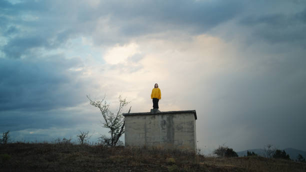 portrait d’une femme en imperméable jaune ressentant et appréciant la beauté de la nature dans la nature en montagne par temps froid et pluvieux - success determination idyllic carefree photos et images de collection