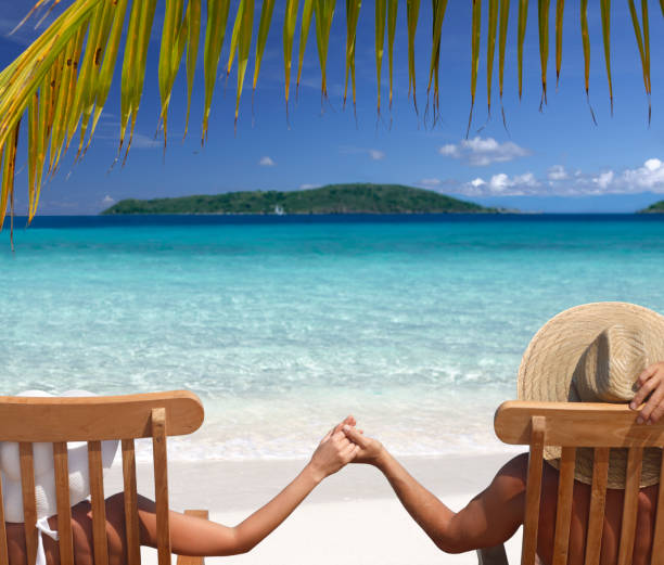 Couple relaxing in teak chairs on beautiful beach