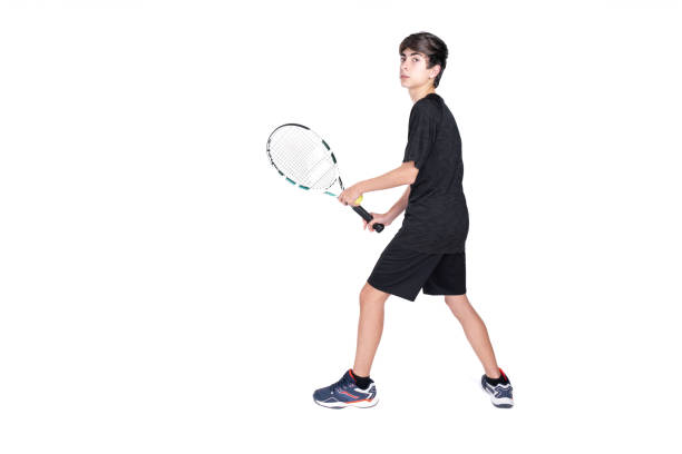 un adolescent joue au tennis et attend que son adversaire serve de prisonnier. photographié dans un studio avec fond blanc - tennis child athlete sport photos et images de collection