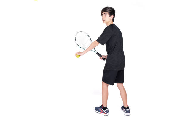 un adolescent jouant au tennis photographié dans un studio sur fond blanc - tennis child athlete sport photos et images de collection