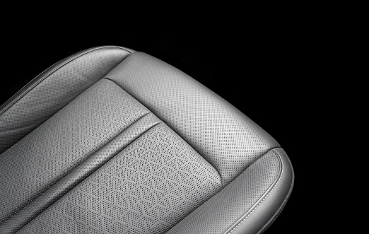 Car black leather interior. Part of black leather car seat details with white stitching. Interior of prestige car. Perforated leather seats isolated on black. Perforated leather.