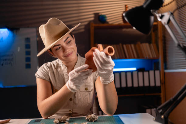 istock Archeologist working with antique vessel late night in office 1727909044