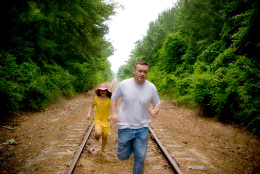 A family running down some train tracks.