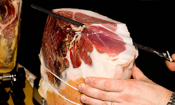 ham Delicious Italian ham from Modena cut with knife parma ham stock pictures, royalty-free photos & images