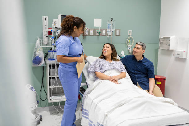 istock Husband and wife smile while the nurse jokes with them 1727918671