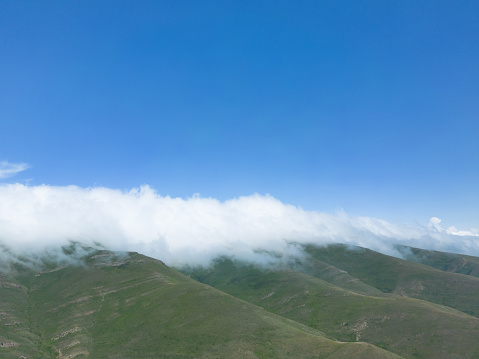 Aerial view mountain. Scenic aerial view mountain ridge. Above green landscape with sunlight mountains covered with clouds